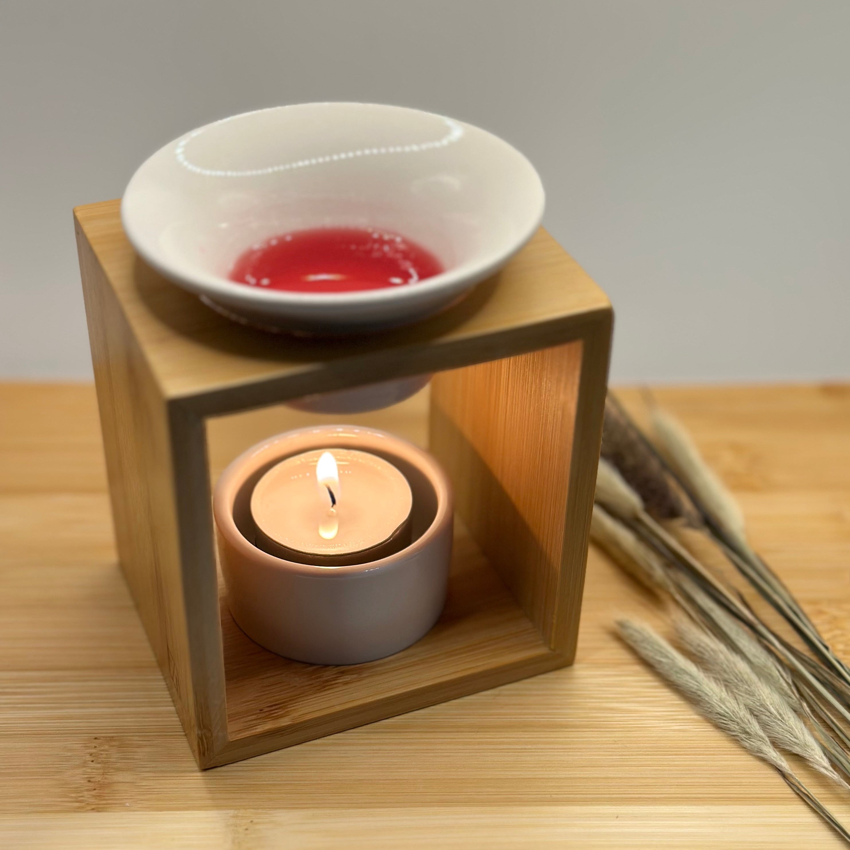 Bamboe waxbrander met brandend waxinelichtje en gesmolten wax in wit schaaltje