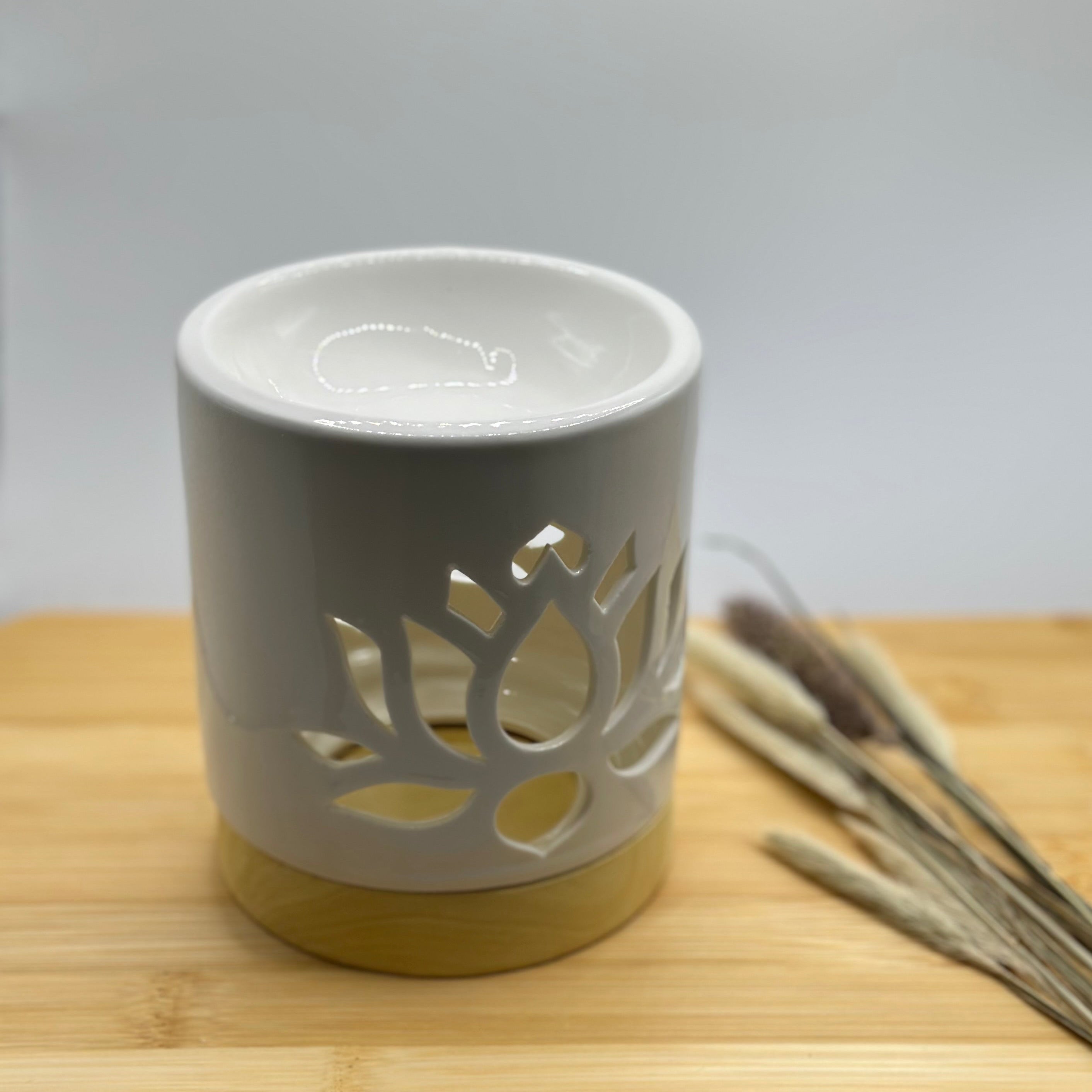 Waxbrander lotusbloem van wit keramiek met decoratieve uitsnede en houtlook onderkant, detail van het schaaltje bovenop