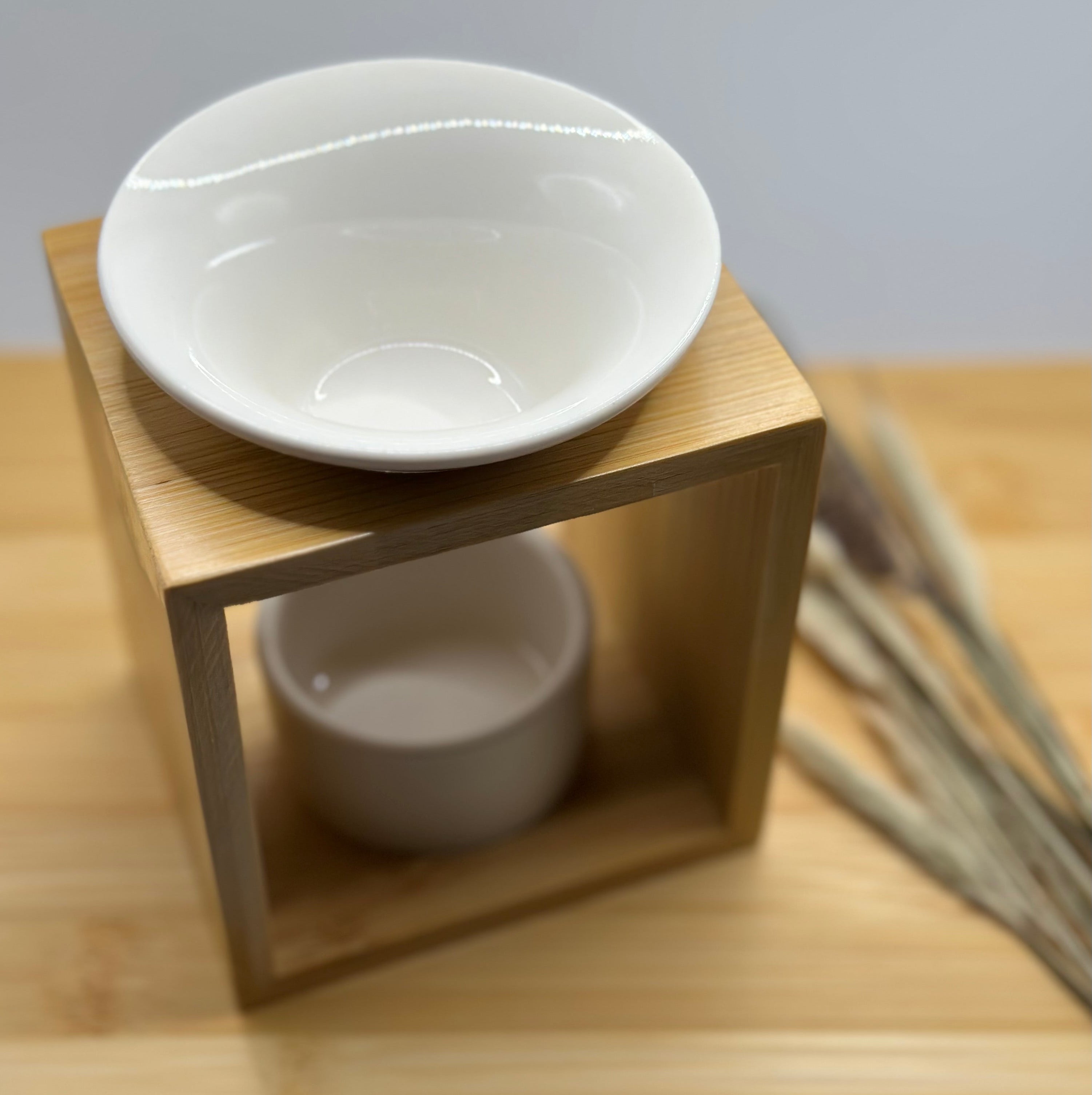 Wit keramiek schaaltje op bamboe waxbrander voor het smelten van wax melts